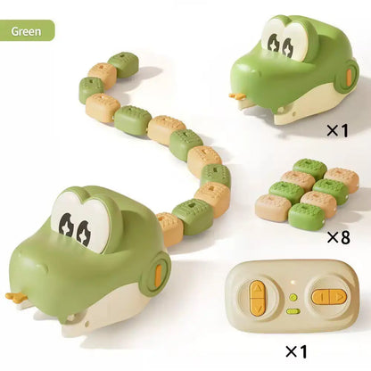 A green and cream robotic snake toy set shown on a white background, including two crocodile-head robots, a beige remote control, and multiple small square food pieces. A green label in the top left reads 'Green' and quantity multipliers x1, x8, and x1 appear beside the components.